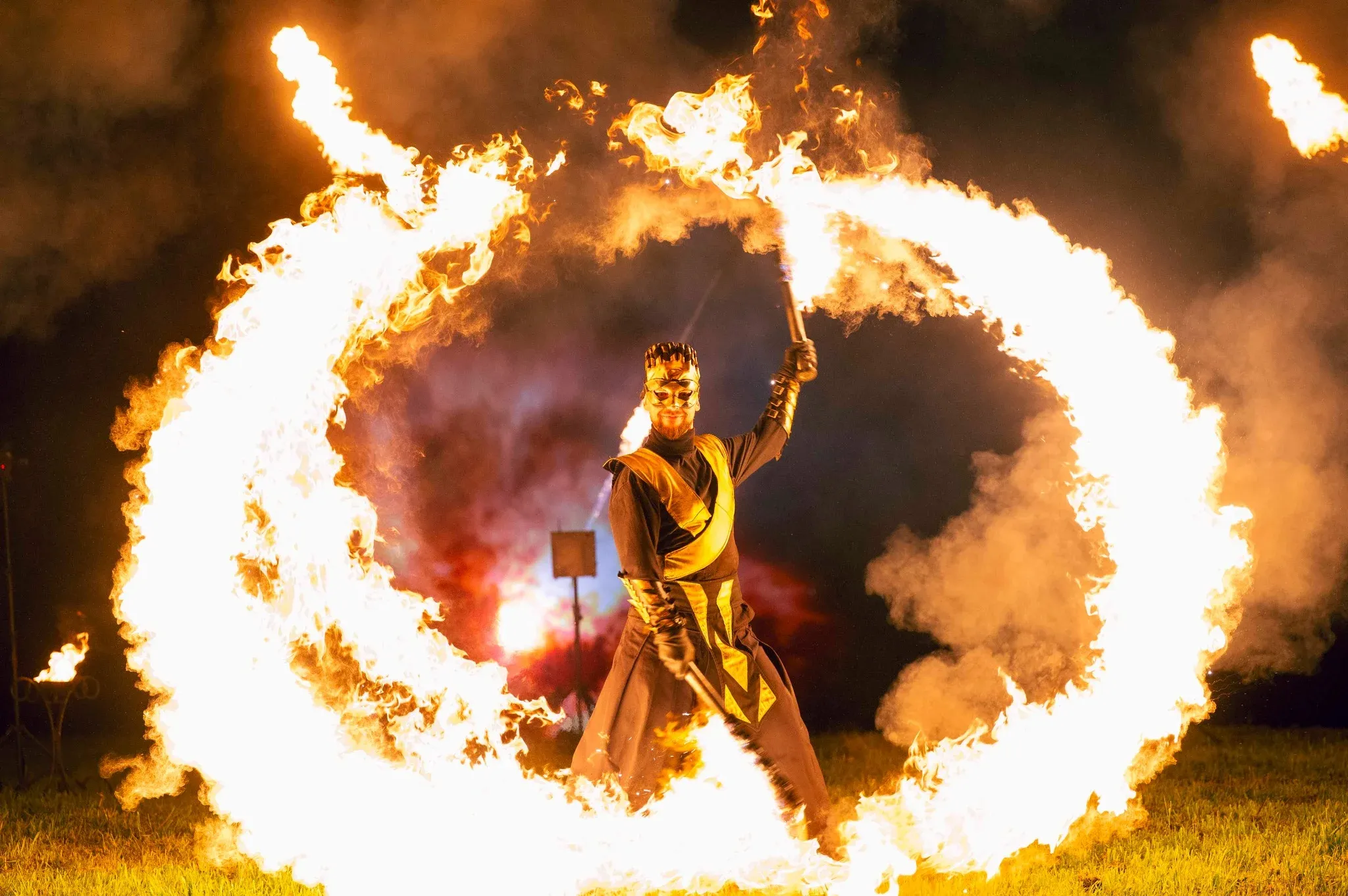 A fire performer spinning a blazing ring of fire on stage