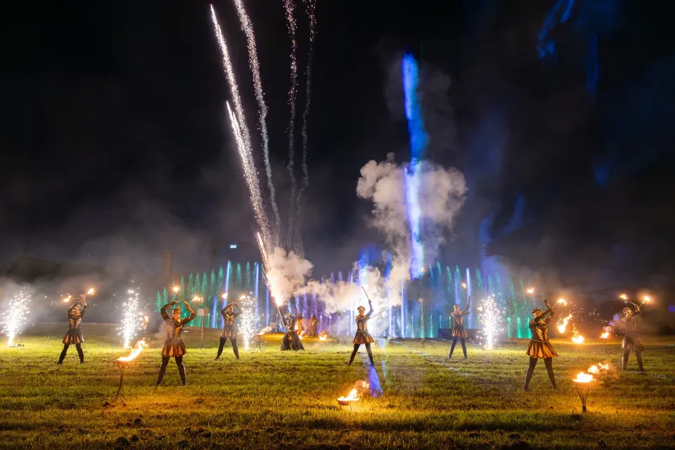 Wirujące koło ognia sypie złotymi iskrami w nocnej ciemności