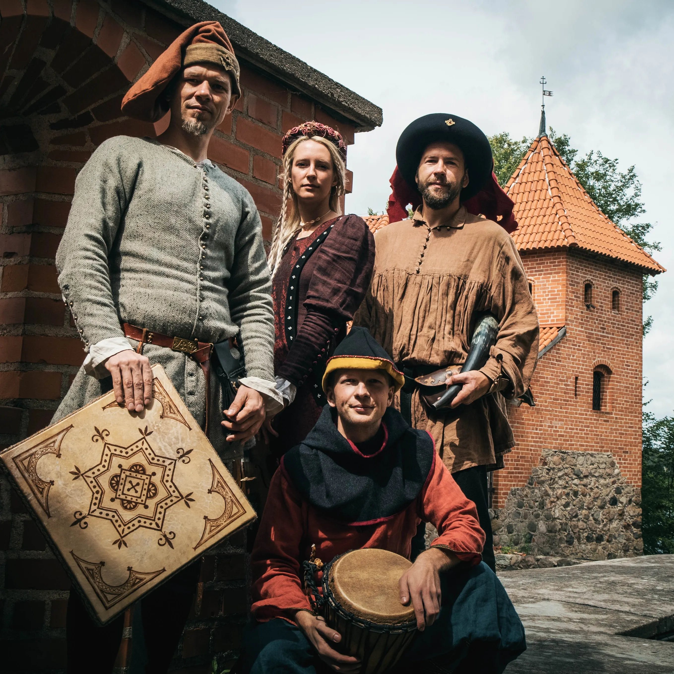 The Ambera group poses with their instruments by a castle tower