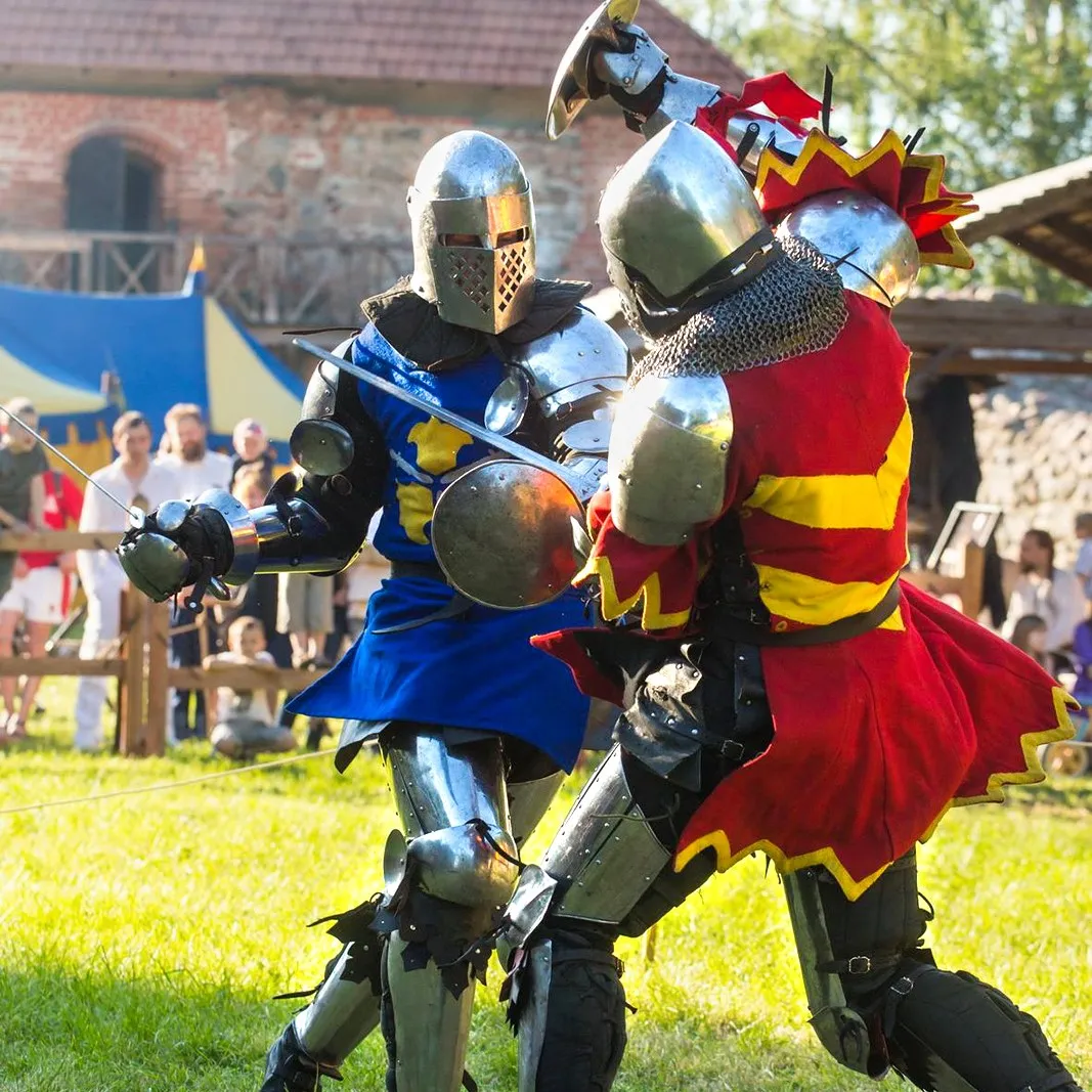 Knights clash swords in close combat on a grass field
