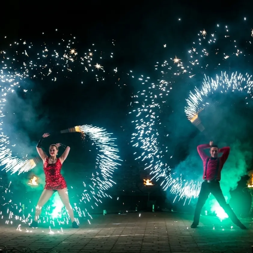 A duo on stage surrounded by glittering rings of sparks