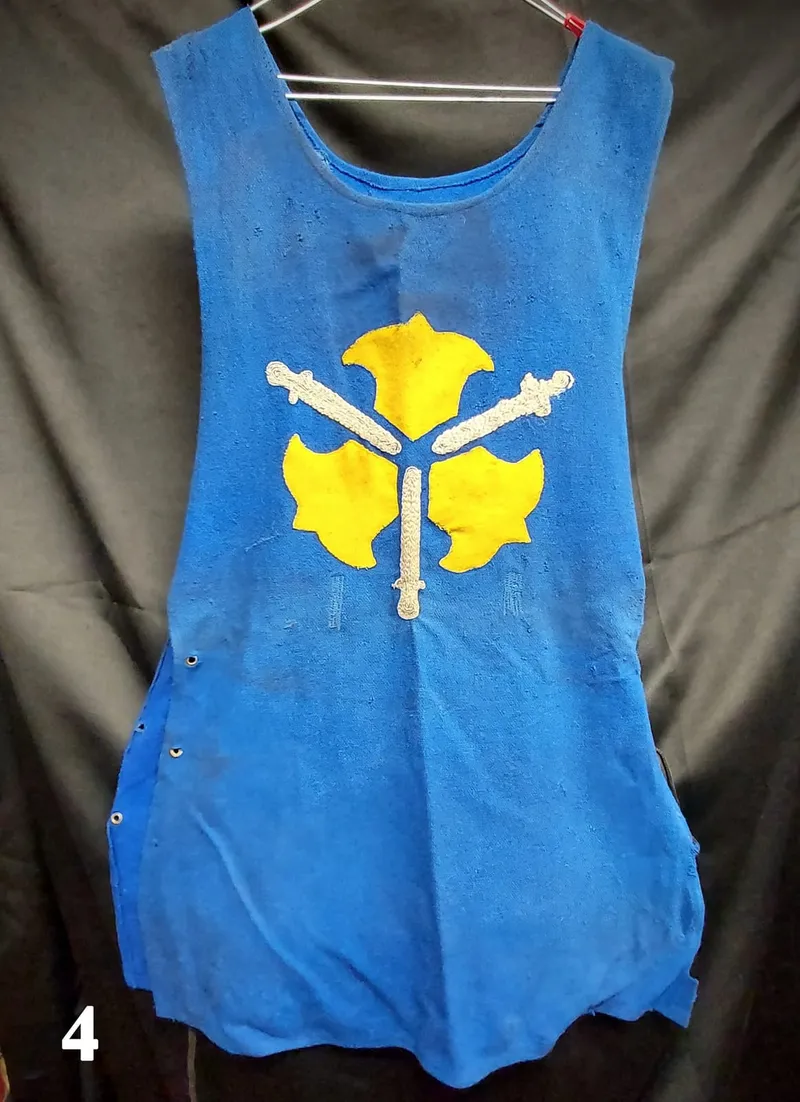 Blue heraldic tunic with a yellow coat-of-arms emblem