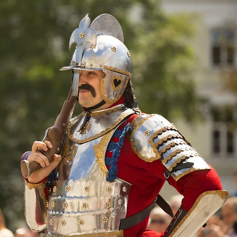 A hussar with an ornate helmet and a musket resting on his shoulder