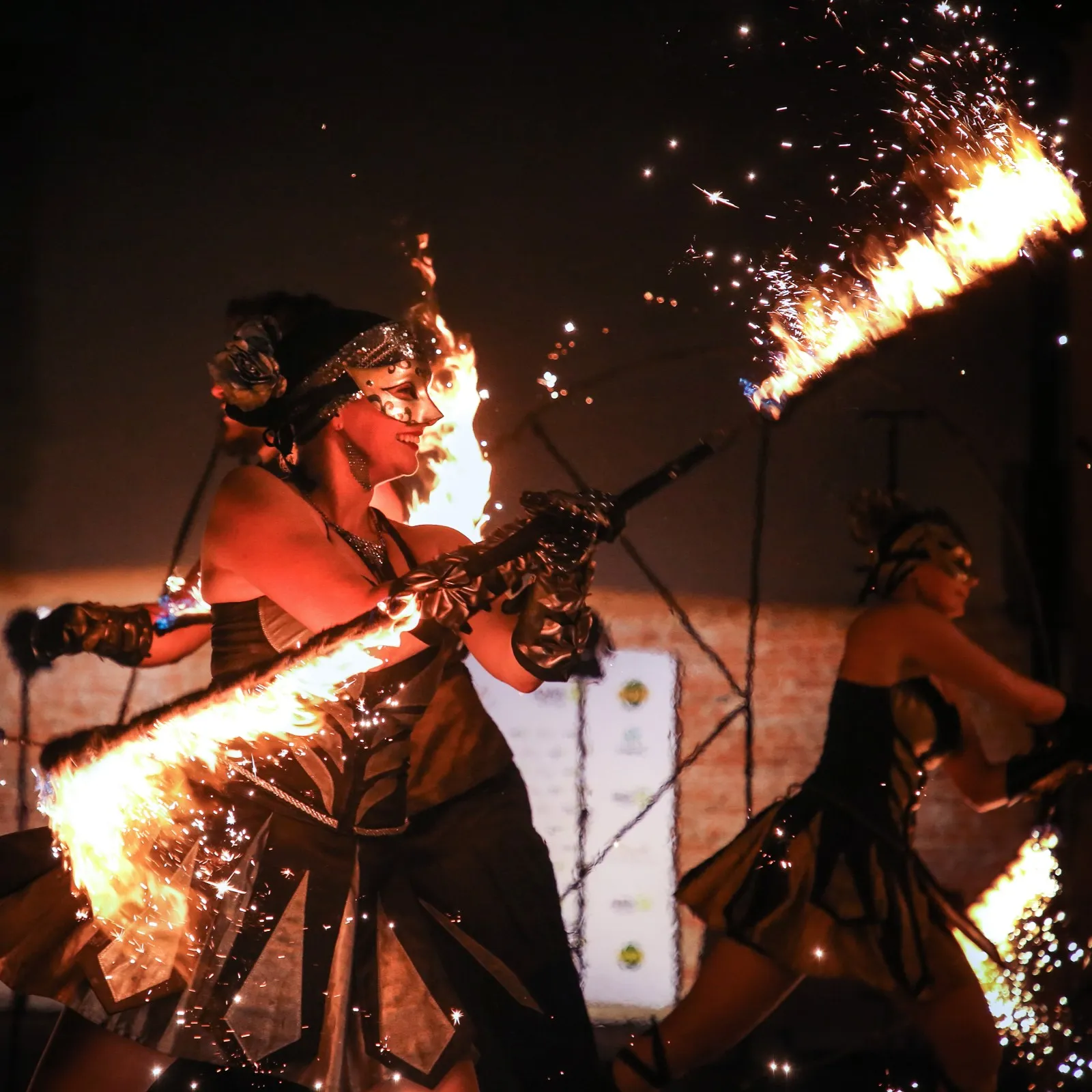 Costumed performers wield a blazing sword on stage