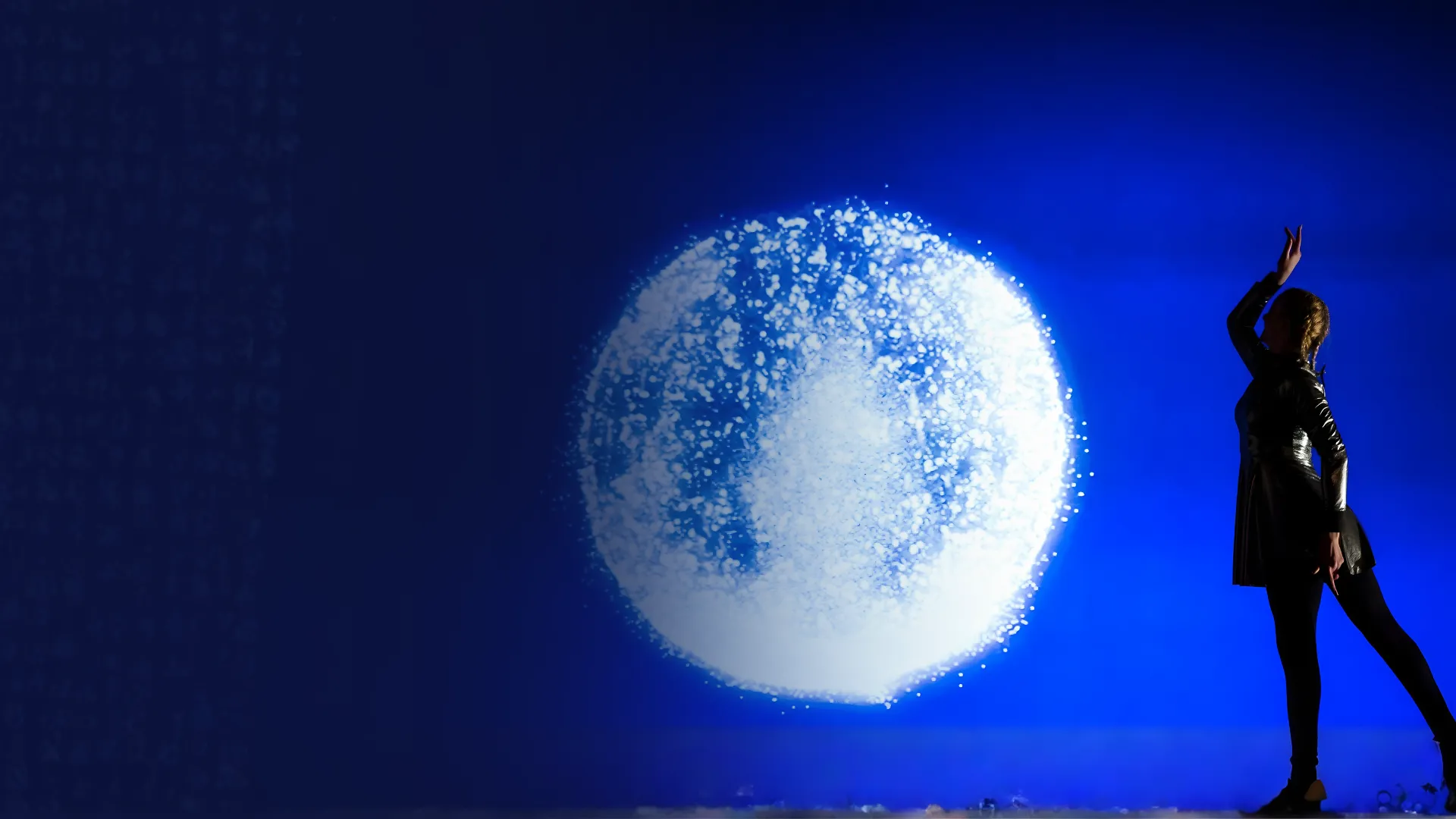 Interactive light projection forming a glowing moon shape on stage