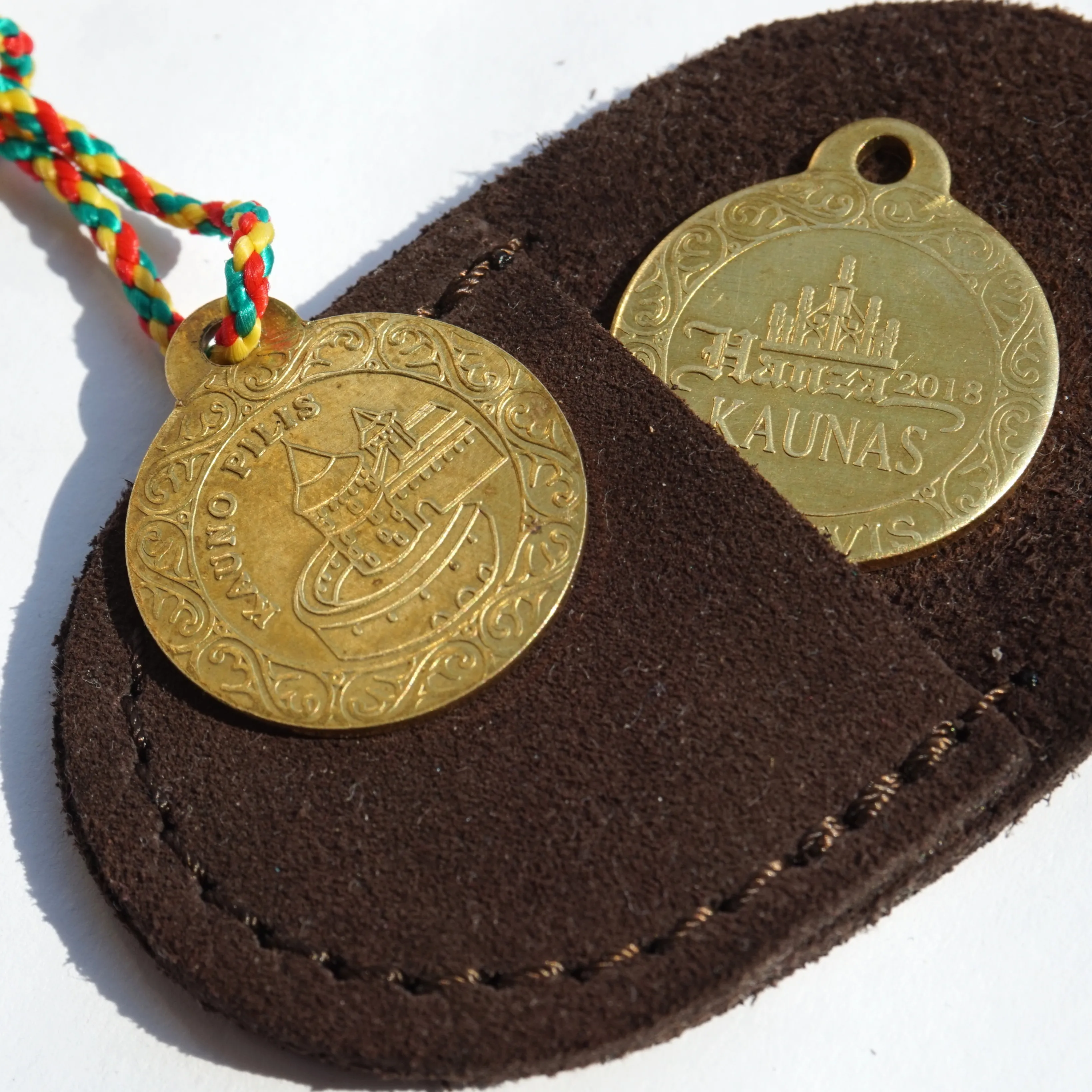 Two souvenir Kaunas Castle coins attached to a leather pouch