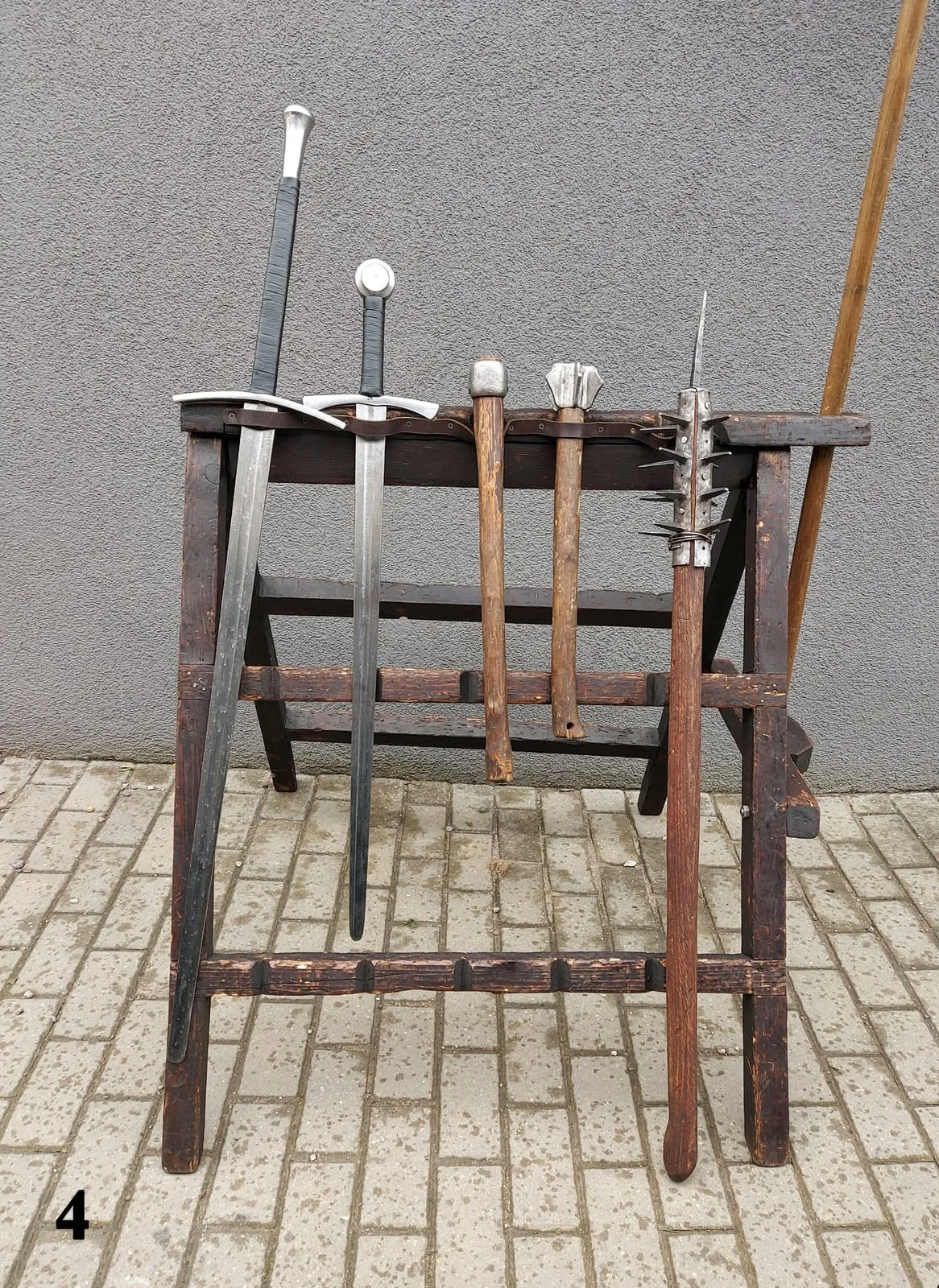 Wooden weapons rack with swords in an outdoor camp