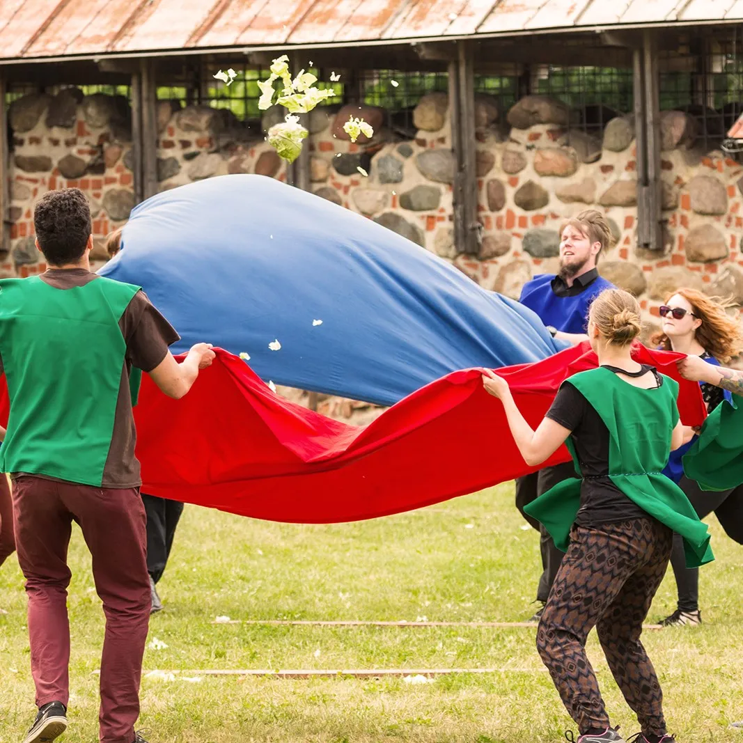 A team launches an object with a cloth sling during an outdoor task