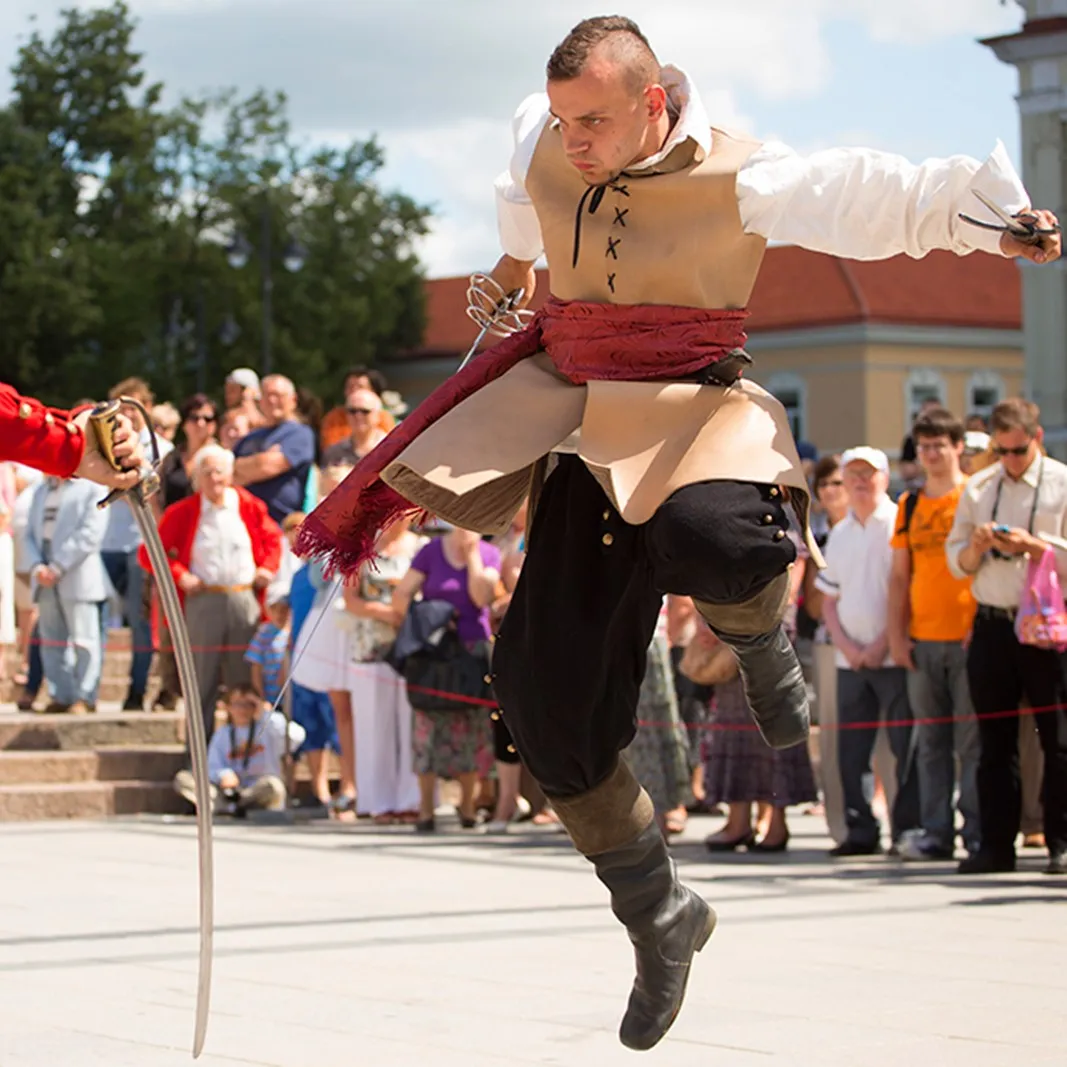 A fighter leaps mid-air with a sword in hand during a duel