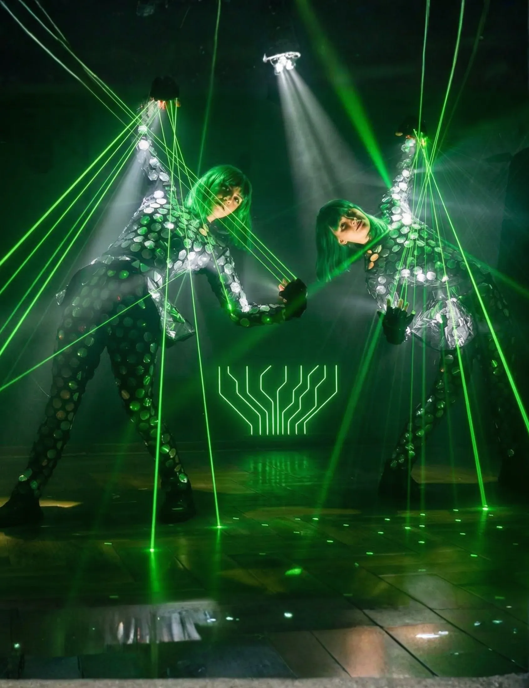 Two Lazerdance performers on stage with green laser beams streaming from their fingers