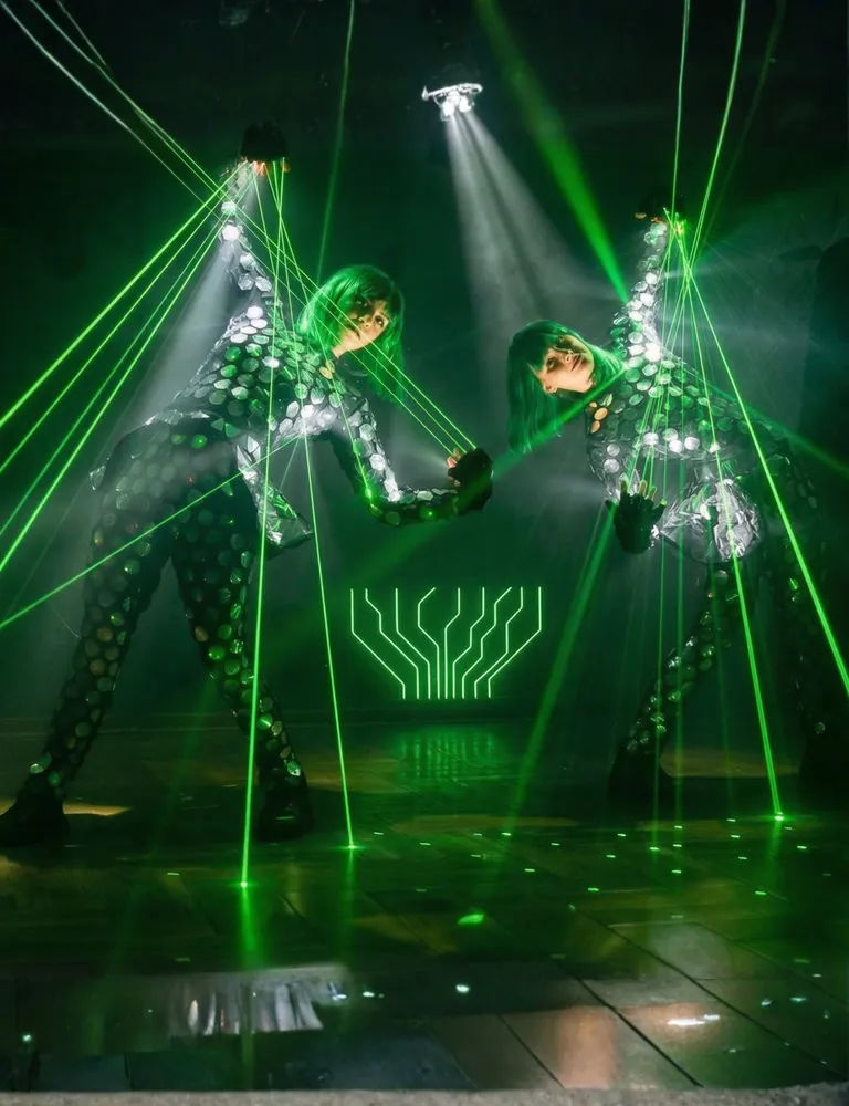 Divas Lazerdance dejotājas uz skatuves ar zaļiem lāzera stariem no pirkstiem