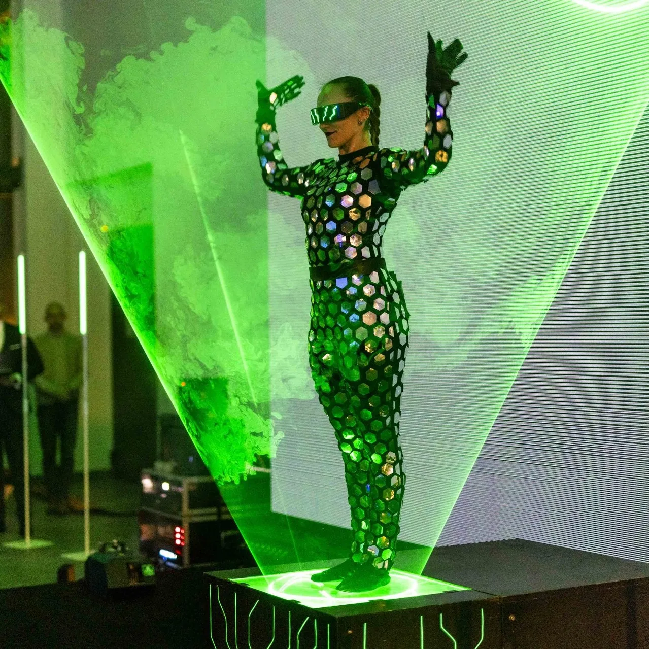 The performer dances amid multicoloured laser beams on stage