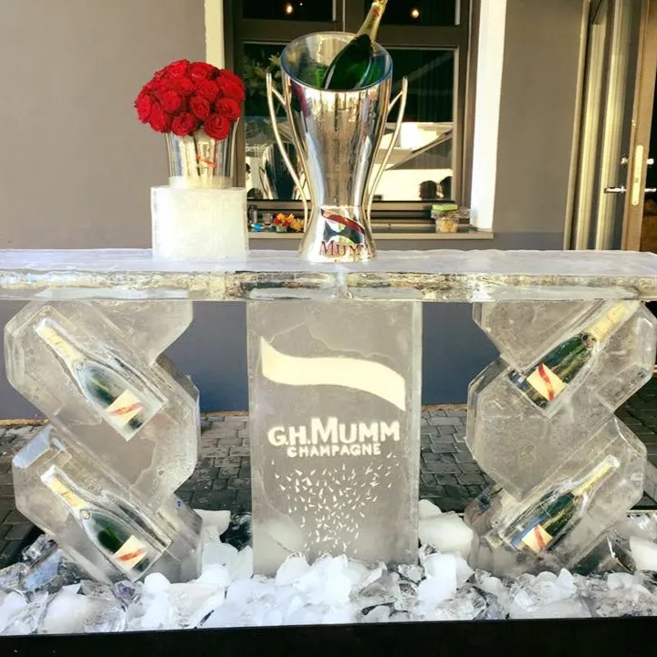 Ice bar sculpture holding champagne bottles and roses for an event