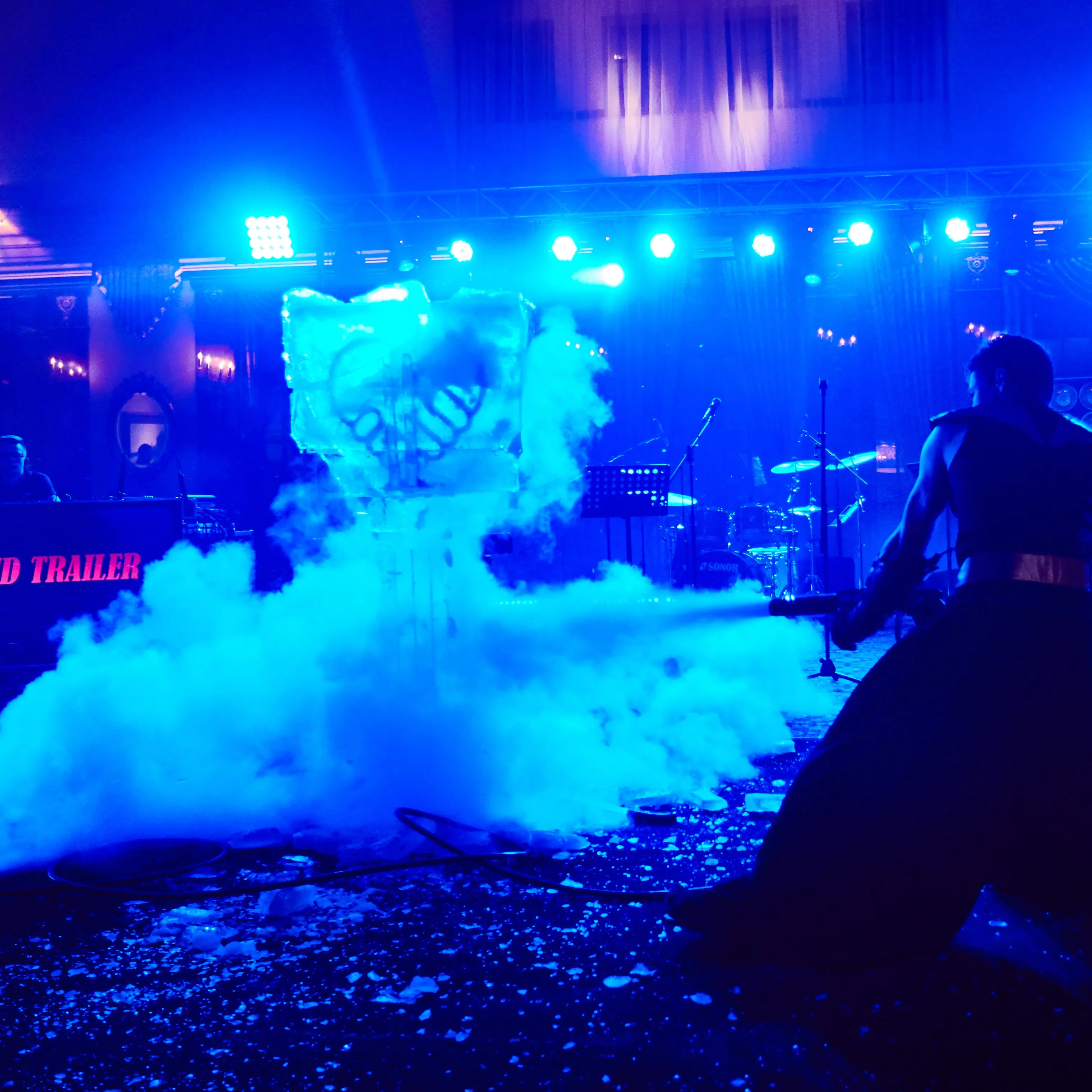Ice sculpture wrapped in fog under blue stage lighting during the show