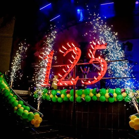 A flaming anniversary number with sparks and balloons around it
