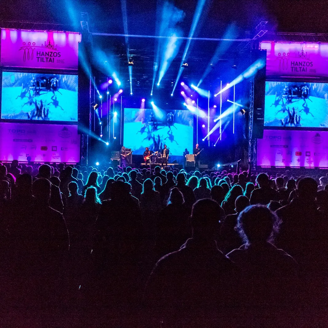 A large concert stage with a light show at a city festival