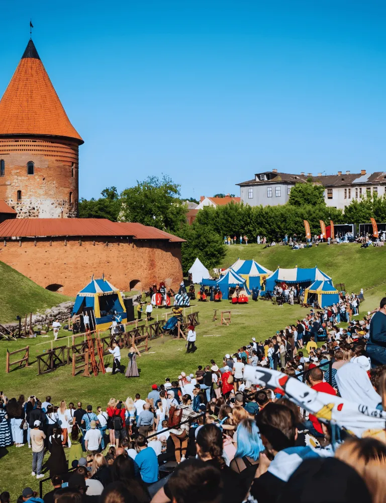 Bruņinieku turnīru vēro milzīgs pūlis pie senas pilis