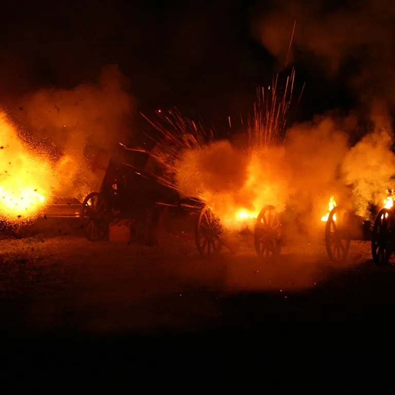 Several cannons fire with dramatic flames during a night-time show