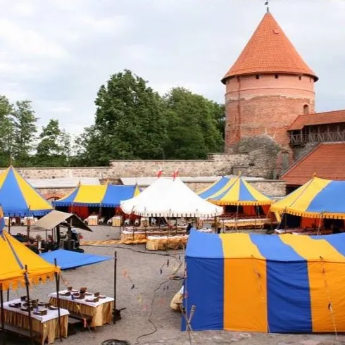 A colorful tent camp set up beside Trakai Castle's tower