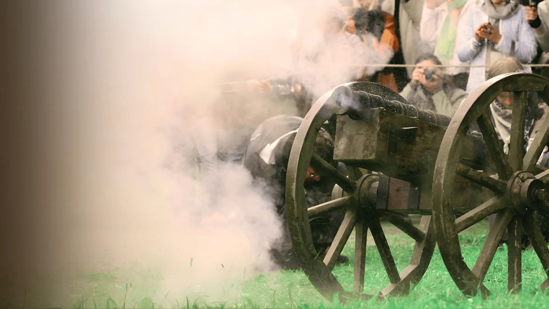 A cannon wheel wrapped in smoke right after firing at an event
