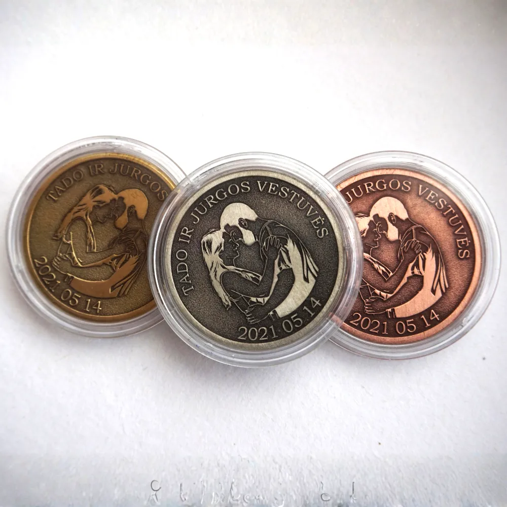 Three personalised wedding coins in different metal tones, engraved with a couple
