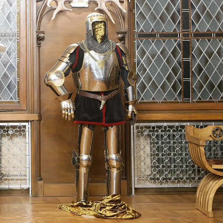 A complete suit of knight's armor on display in a hall