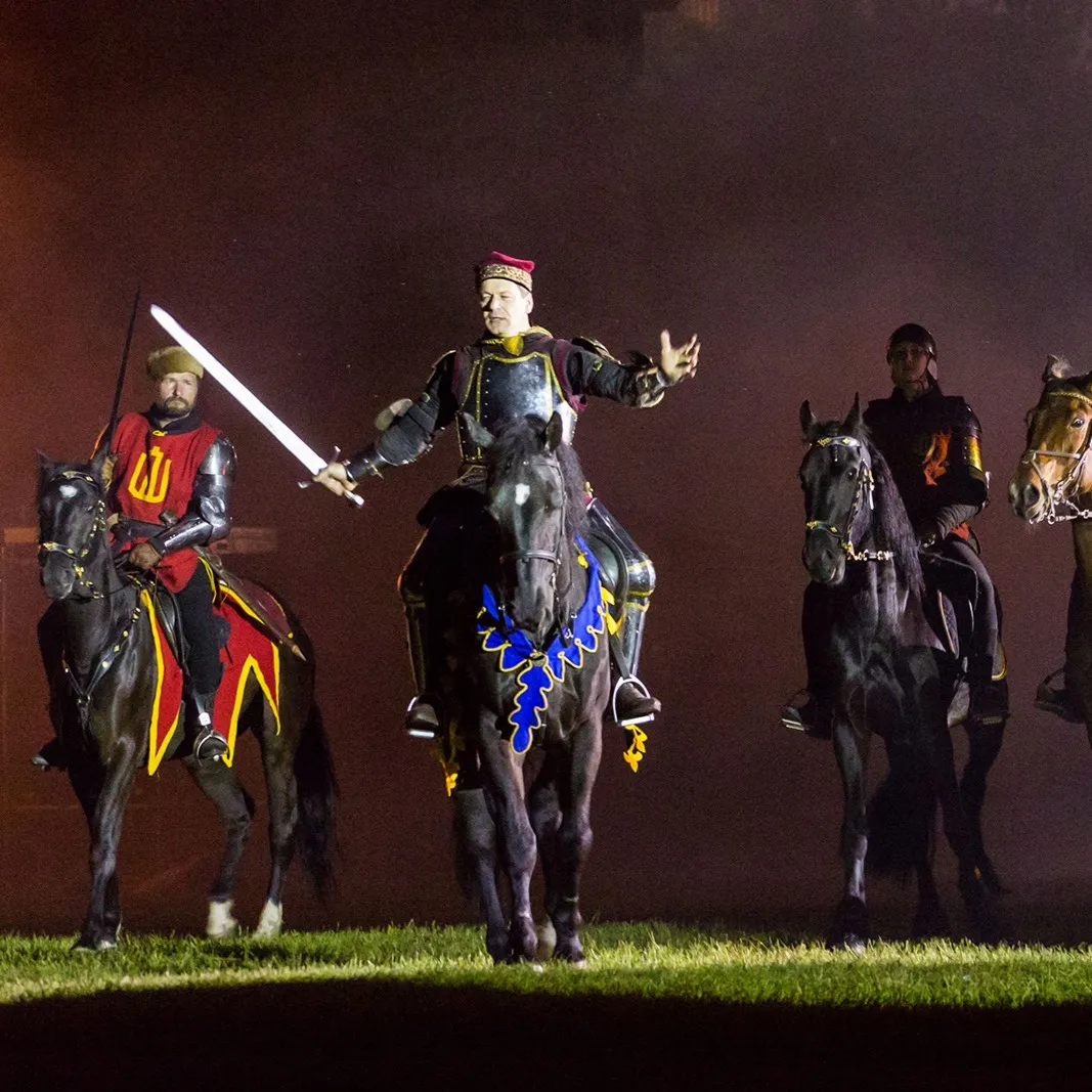 Horsemen with flags in a staged night scene