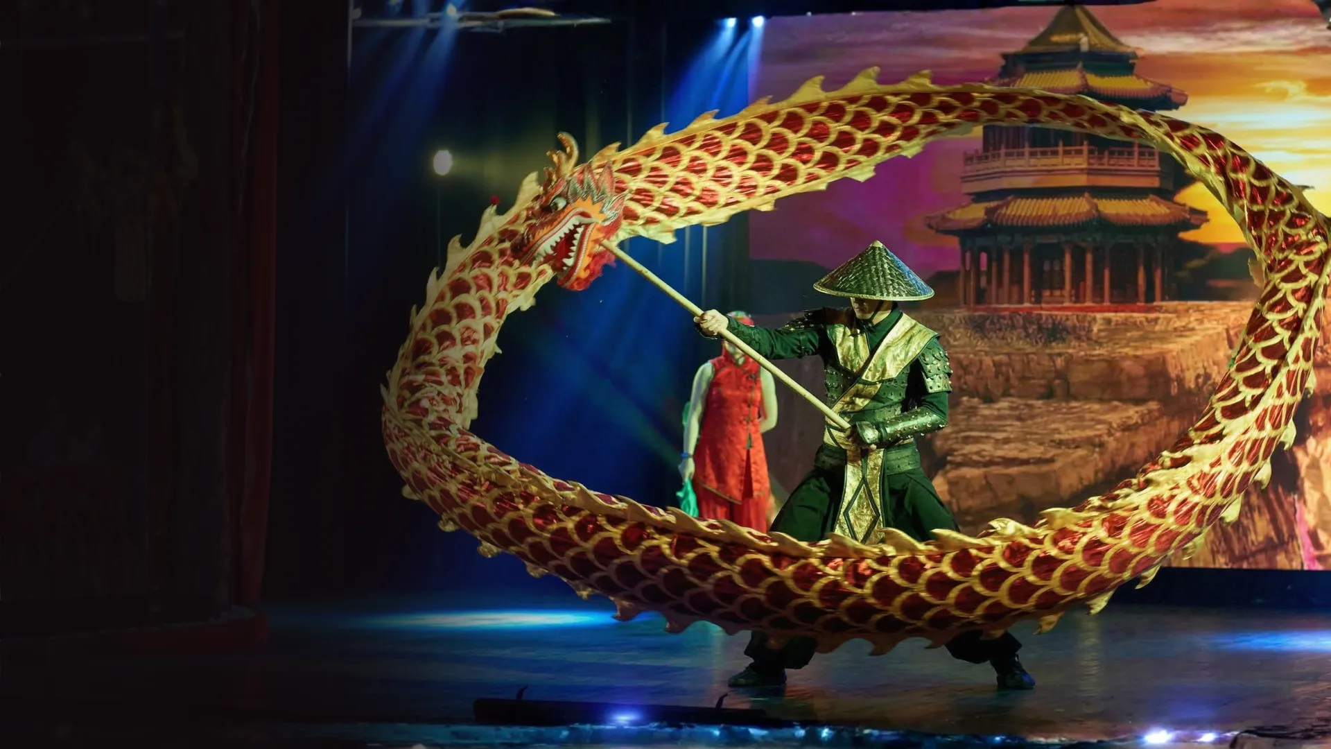 A red-and-gold Chinese dragon prop held aloft by a performer on stage