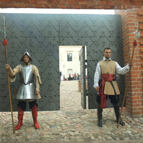 Two knights with halberds open the great castle gates