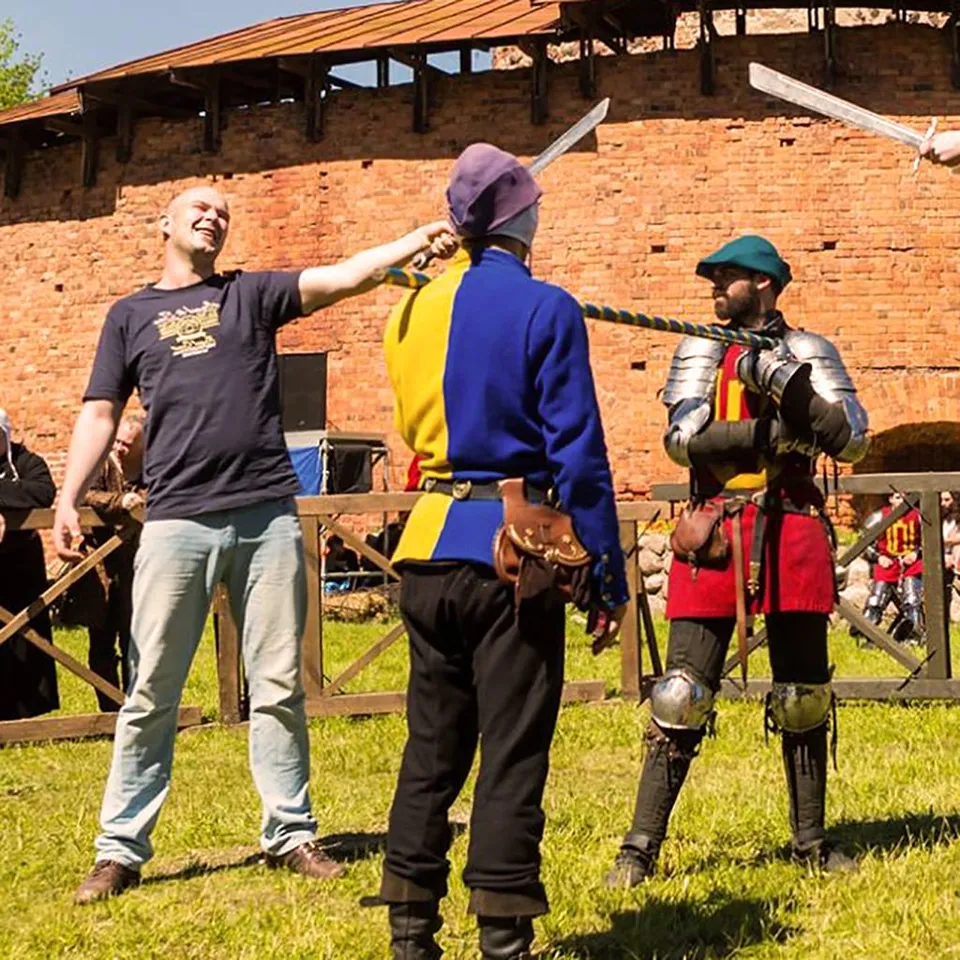 Bruņinieki māca viesiem spēka sacensību ar virvi zālājā