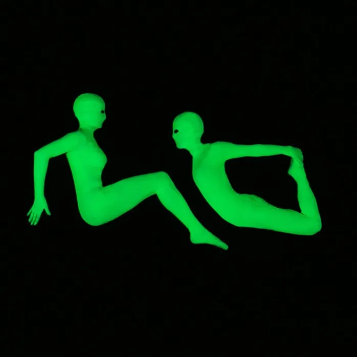 Two glowing performers create a UV levitation illusion in the dark