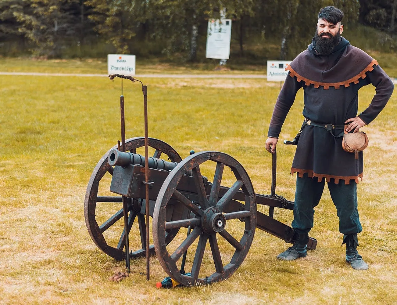 Historical cannon on wooden wheels with a gunner in period costume