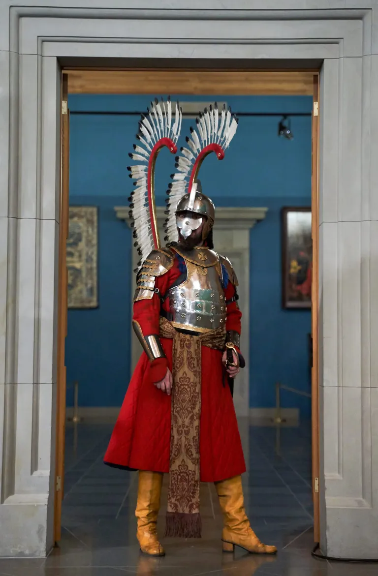 Spārnotais huzārs bruņās ar spārniem stāv zāles durvīs