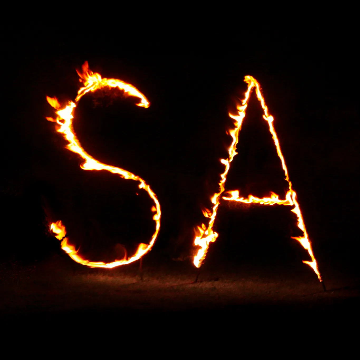 A row of diamond-shaped fire sculptures in the snow lit with blue light