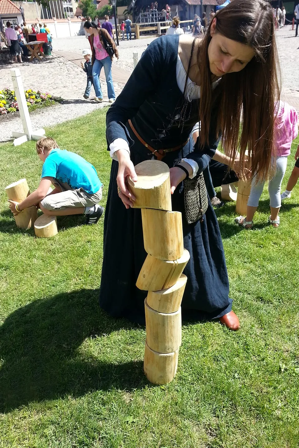 Child building a tower of wooden rounds in a balance game