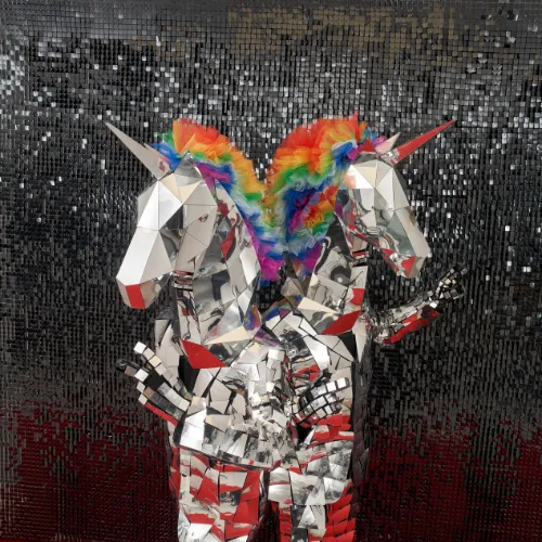 Two mirror-mosaic unicorn-head characters with a rainbow-coloured mane
