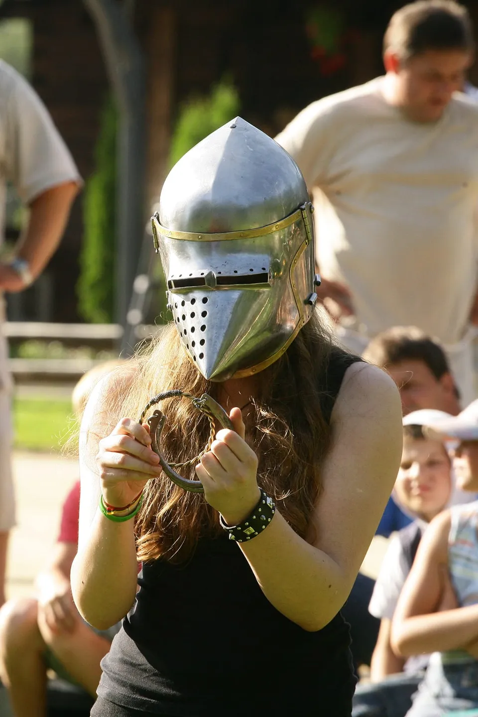 Visitor trying on a knights helmet at an excursion stop