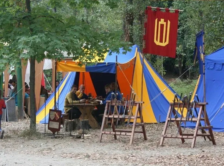 Amatininkų palapinė miško stovykloje su vėliava ir stalu