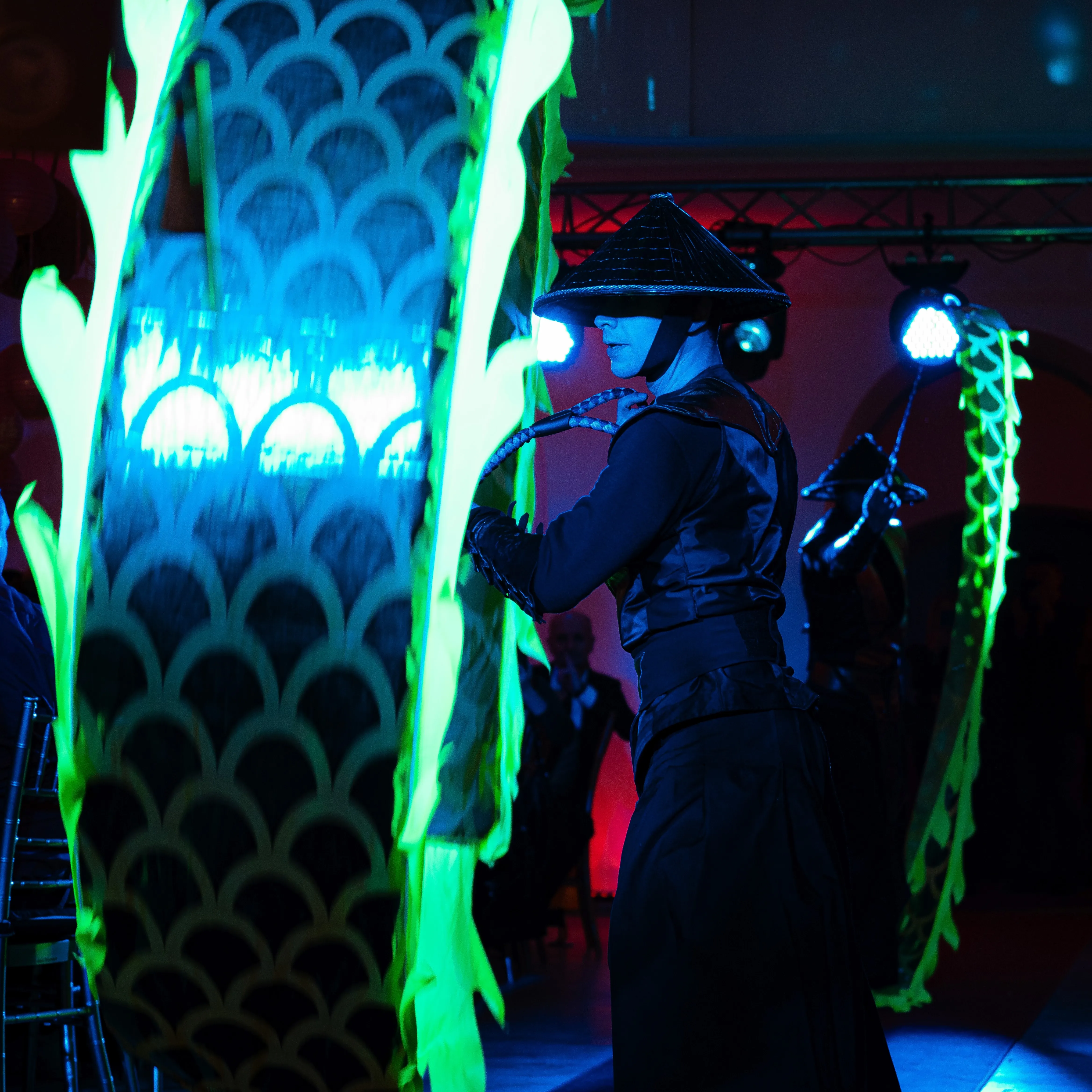 A close-up of the green Chinese dragon fabric and its handler backstage